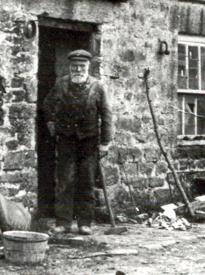 Photograph of William Bell standing outside the smithy